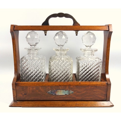 479 - Late Victorian oak tantalus with silver plated mounts and three wrythen and cut glass decanters, (wi... 