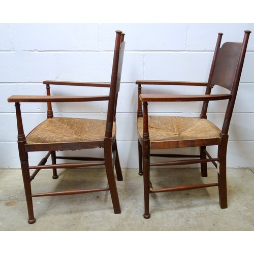 499 - A pair of oak Arts & Crafts chairs by William Birch, the shaped backs with turned supports, rush sea... 