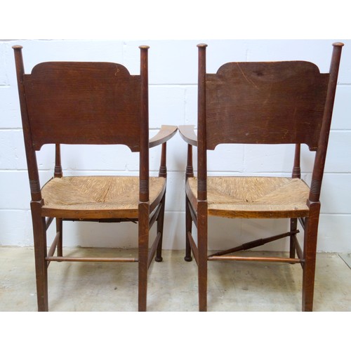 499 - A pair of oak Arts & Crafts chairs by William Birch, the shaped backs with turned supports, rush sea... 