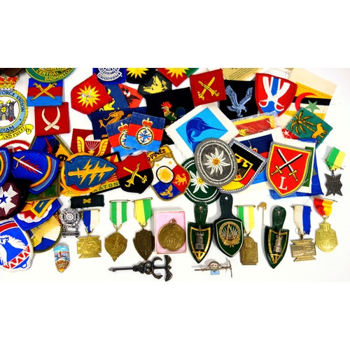 99 - Quantity of Military cloth badges (50+), copy of an SAS belt, metal badges, SAS crest on elm plaque,... 