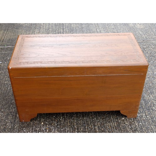 327 - Oriental teak chest with carved bands, hinged top and camphorwood lined interior with sliding tray, ... 