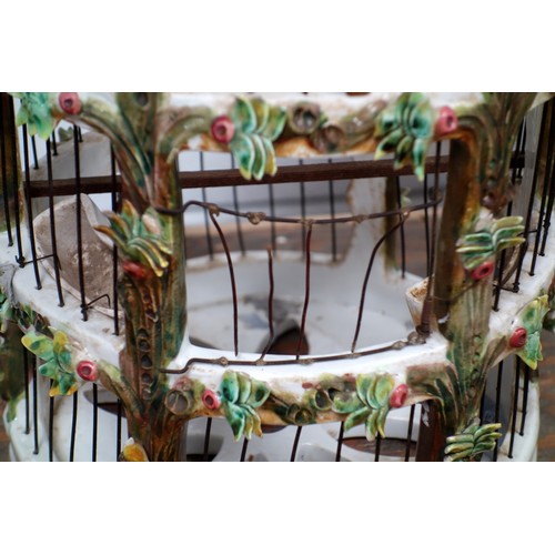 164 - Italian ceramic cylindrical birdcage with all-over encrusted floral decoration, door a/f, with two t... 