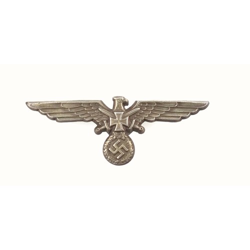 58 - WW2 German Eagle and crossed swords cap badge, the reverse with three metal prongs and stamped 3 GES... 