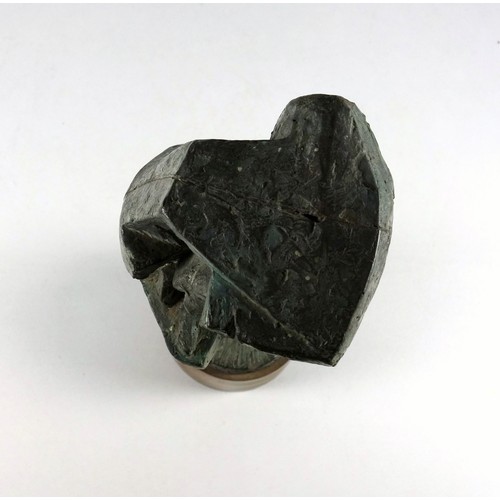 26 - Bronzed resin abstract sculpture as a giant nail of a miner kneeling in a rock crevice, on a teak ci... 