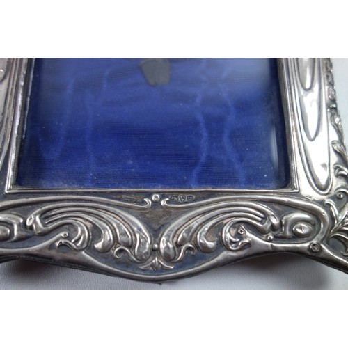 34 - Edwardian silver mounted photograph frame with embossed scrolling decoration and vacant cartouche ab... 