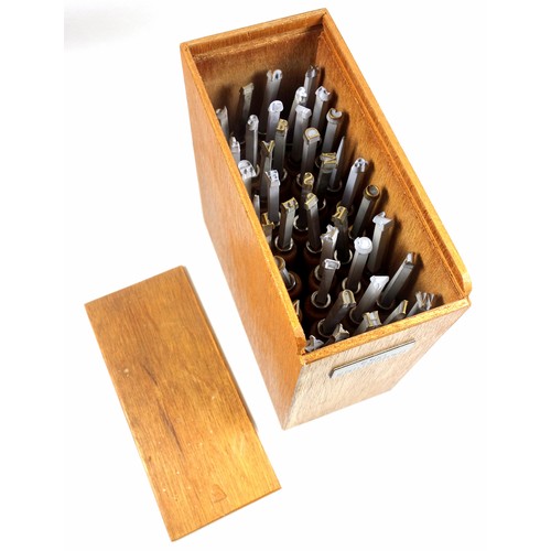 111 - Wooden box containing 40 gold finishing hand tools comprising complete alphabet, numbers 1-9, ampers... 