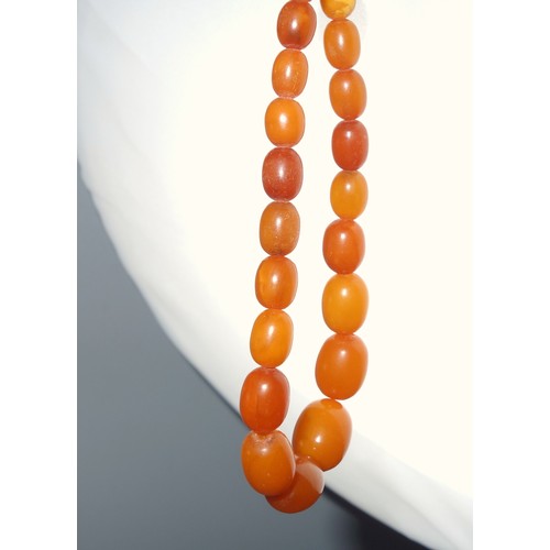 82 - Amber graduated bead necklace, L.45cm; 2 amber bracelets and a pendant, 66.2grs, and a bar brooch se... 