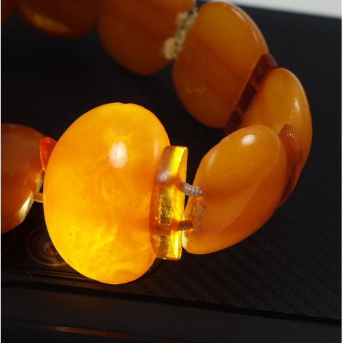 82 - Amber graduated bead necklace, L.45cm; 2 amber bracelets and a pendant, 66.2grs, and a bar brooch se... 