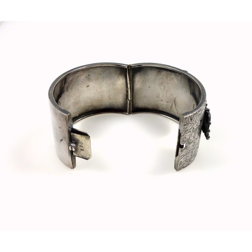 83 - Late Victorian silver bangle with semi engraved floral decoration with a raised strap and swivel buc... 