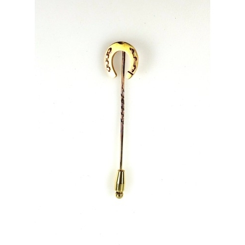 111 - 18ct gold horseshoe on a 15ct gold stickpin, gross 6.4 grams