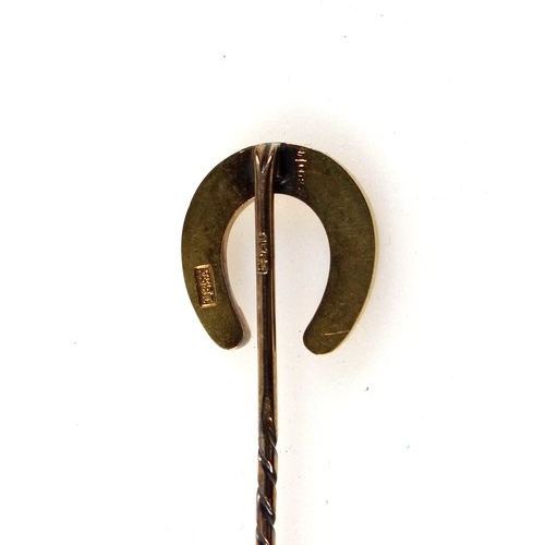 111 - 18ct gold horseshoe on a 15ct gold stickpin, gross 6.4 grams