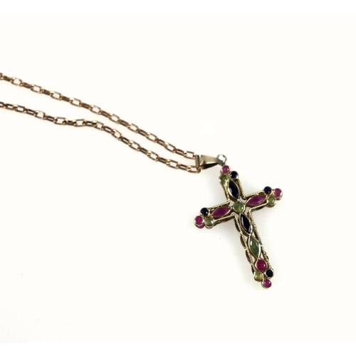 123 - 9ct gold filigree double-sided cross studded with a variety of shaped rubies, blue and green sapphir... 