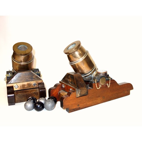 194 - Pair of models of bronze mortars, each on a wood base with a powder barrel, length of barrel 16cm ov... 