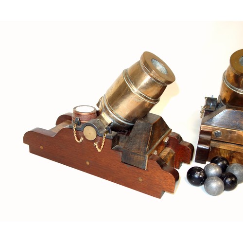 194 - Pair of models of bronze mortars, each on a wood base with a powder barrel, length of barrel 16cm ov... 