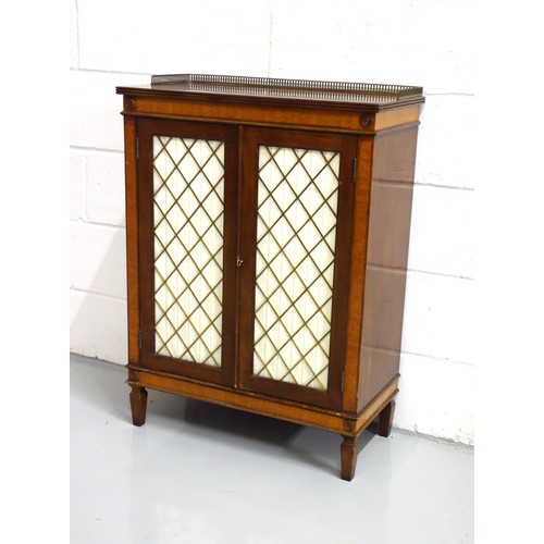 218 - Regency style mahogany and satinwood cabinet with 2 brass lattice and pleated fabric panelled doors,... 