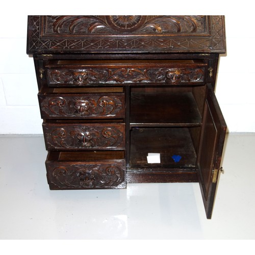 229 - Victorian carved oak bureau with a fall front and 4 drawers and a panelled door below, 125 x 91 x 50... 