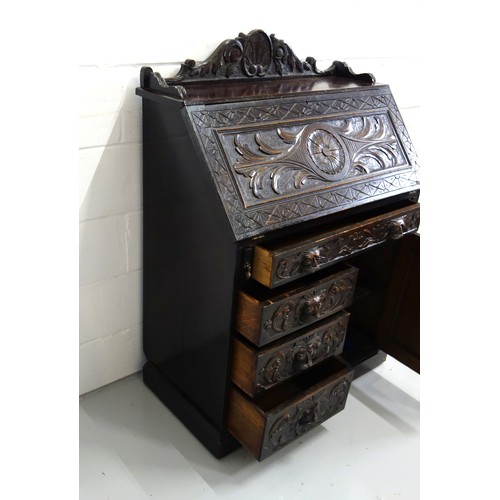 229 - Victorian carved oak bureau with a fall front and 4 drawers and a panelled door below, 125 x 91 x 50... 