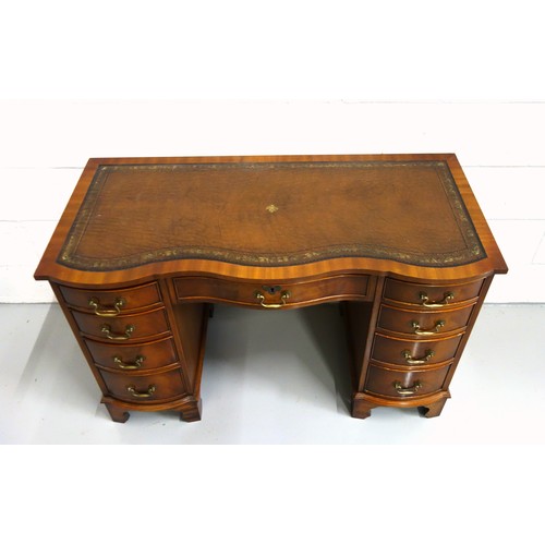 231 - Bevan Funnell Reprodux mahogany serpentine pedestal desk with an inset gilt tooled brown leather top... 