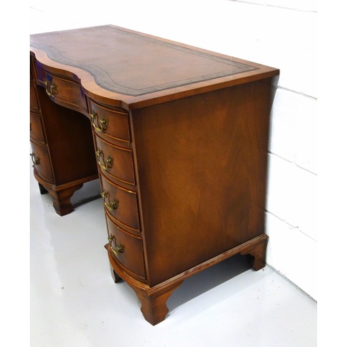 231 - Bevan Funnell Reprodux mahogany serpentine pedestal desk with an inset gilt tooled brown leather top... 