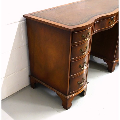 231 - Bevan Funnell Reprodux mahogany serpentine pedestal desk with an inset gilt tooled brown leather top... 