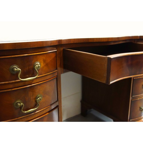 231 - Bevan Funnell Reprodux mahogany serpentine pedestal desk with an inset gilt tooled brown leather top... 