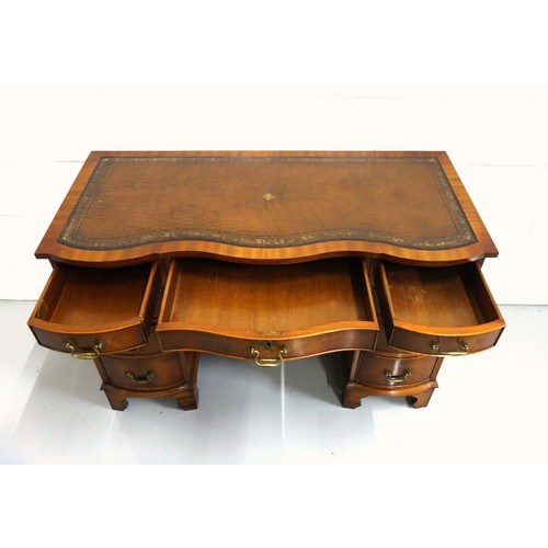 231 - Bevan Funnell Reprodux mahogany serpentine pedestal desk with an inset gilt tooled brown leather top... 