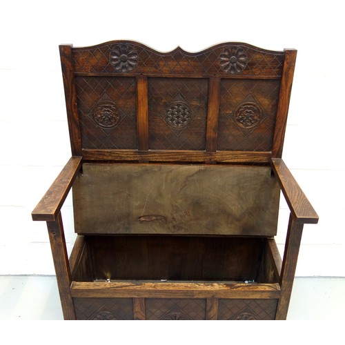 240 - George V elm box seat settle with a panelled back, hinged seat, arms and panelled front, with carved... 