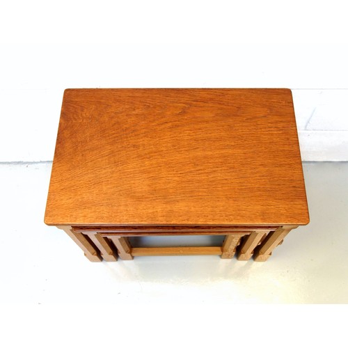 254 - Mouseman, (Robert Thompson), oak nest of three graduating rectangular tables, each with an adzed top... 