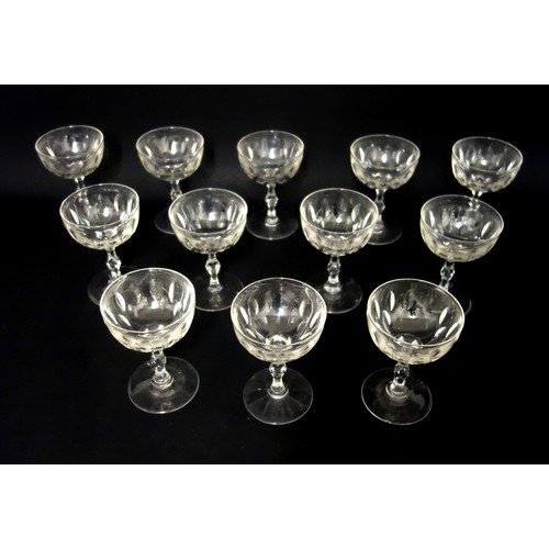 71 - Set of 12 Edwardian cut glass champagne coupes, each with pointed elliptical decoration to the bowl ... 