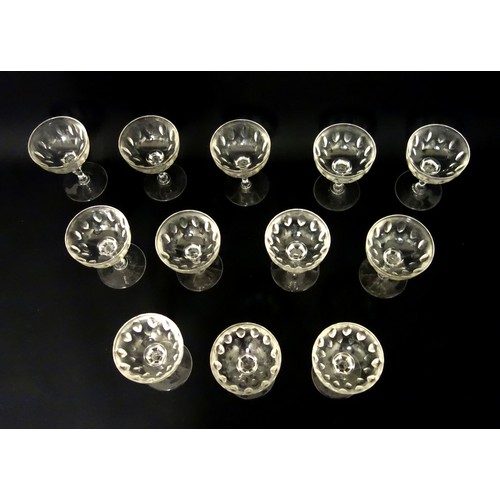 71 - Set of 12 Edwardian cut glass champagne coupes, each with pointed elliptical decoration to the bowl ... 