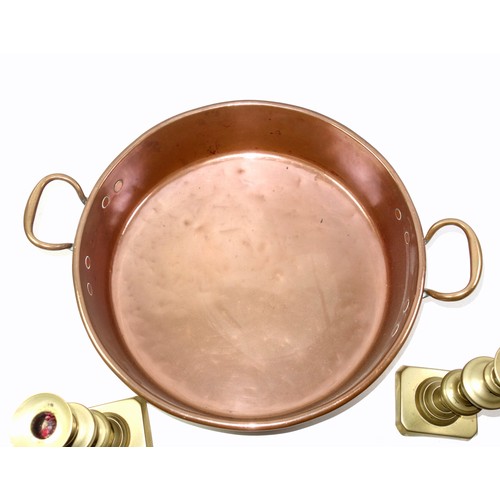 525 - Victorian copper preserve pan with 2 handles, W.54.5cm overall, and a pair of brass candlesticks, ea... 