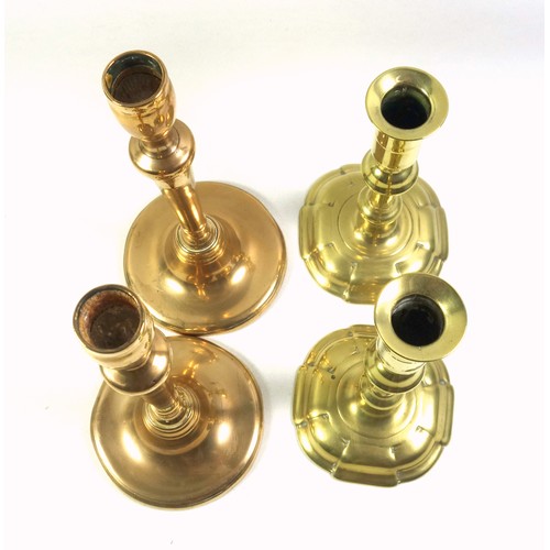 528 - Pair of George II brass candlesticks, each with a tall capital on a knopped baluster column and 