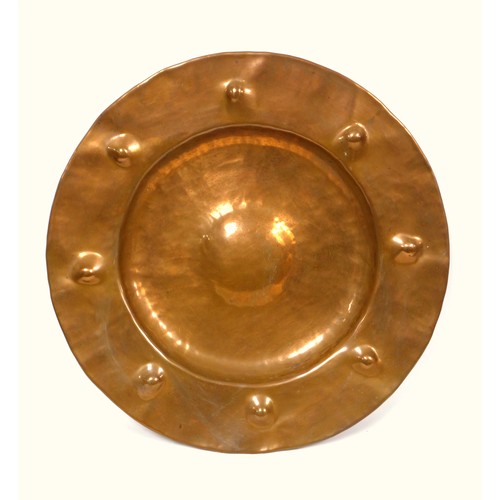 402 - Liberty style copper charger with a raised centre and a broad rim with 8 roundels in relief, Dia.45.... 