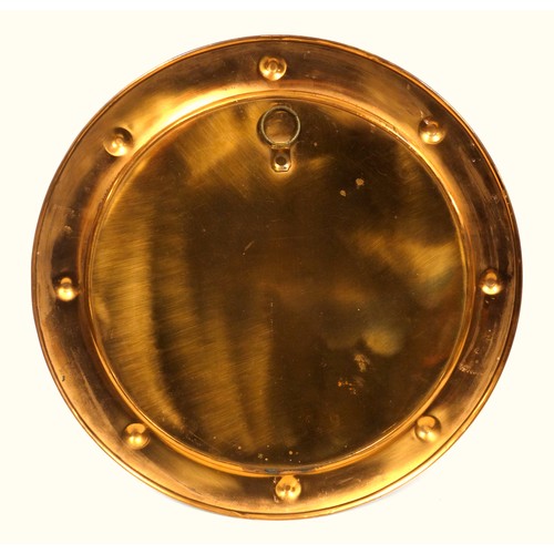 402 - Liberty style copper charger with a raised centre and a broad rim with 8 roundels in relief, Dia.45.... 