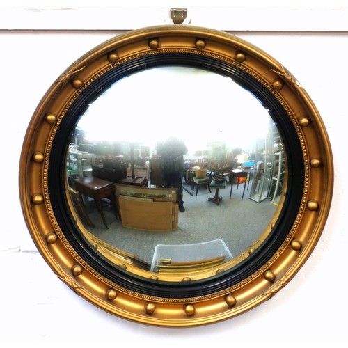 398 - Regency style wall mirror with a convex plate within a reeded ebonised border and gilt ball mounted ... 