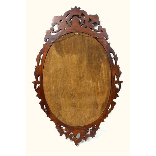 400 - Wall mirror with an upright oval plate, in a mahogany finish moulded scroll and floral frame, 109 x ... 