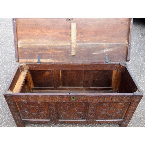 211 - 17th Century carved oak chest with a hinged cover and triple panelled front, on stile feet, 56.5 x 1... 