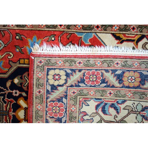 254 - Persian rug, the madder field with an indigo lozenge, ivory spandrels, and all-over floral decoratio... 