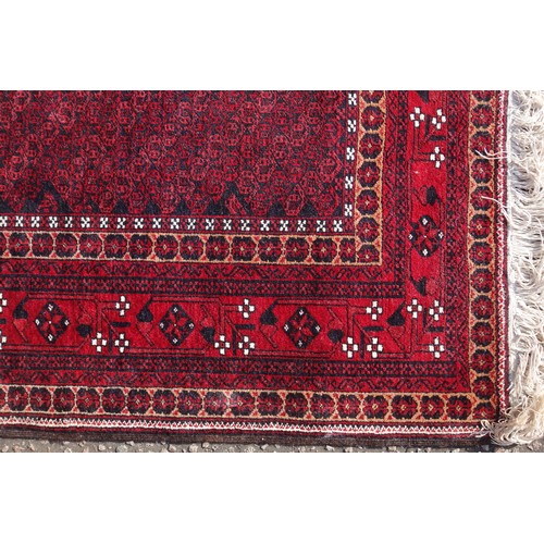 255 - Persian rug, the madder field with all-over geometric pattern, within a floral border and rosette gu... 