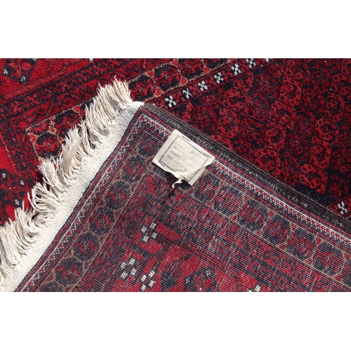 255 - Persian rug, the madder field with all-over geometric pattern, within a floral border and rosette gu... 