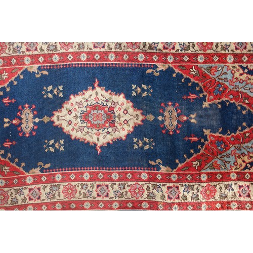 255 - Persian rug, the madder field with all-over geometric pattern, within a floral border and rosette gu... 