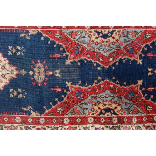 255 - Persian rug, the madder field with all-over geometric pattern, within a floral border and rosette gu... 