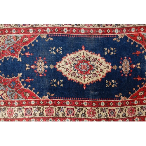 255 - Persian rug, the madder field with all-over geometric pattern, within a floral border and rosette gu... 