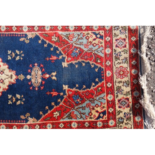 255 - Persian rug, the madder field with all-over geometric pattern, within a floral border and rosette gu... 