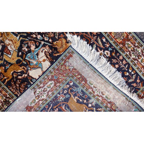 259 - Persian silk rug depicting a hunting scene, the noire field with figures on horseback with hounds hu... 