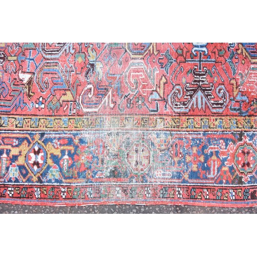 262 - Early 20th Century Persian Heriz carpet, the coral field with all-over scroll decoration, within an ... 