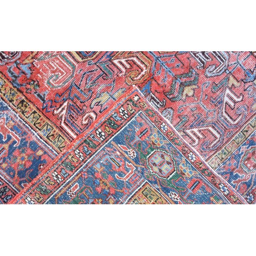 262 - Early 20th Century Persian Heriz carpet, the coral field with all-over scroll decoration, within an ... 