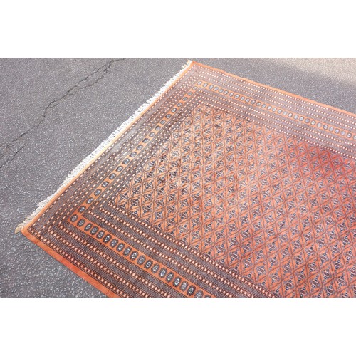 268 - Pakistani carpet, the terracotta field with multiple rows of Chemche guls within a latticework patte... 