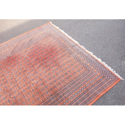 268 - Pakistani carpet, the terracotta field with multiple rows of Chemche guls within a latticework patte... 