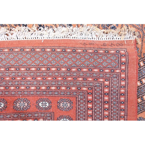 268 - Pakistani carpet, the terracotta field with multiple rows of Chemche guls within a latticework patte... 